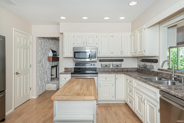 5002 Buffalo Ct, Fort Wayne, IN 46804 - kitchen featuring appliances with stainless steel finishes, a sink, light wood-type flooring, a kitchen island, and wood counters