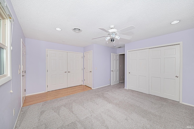 5002 Buffalo Ct, Fort Wayne, IN 46804 - unfurnished bedroom with carpet floors, baseboards, multiple closets, a textured ceiling, and recessed lighting