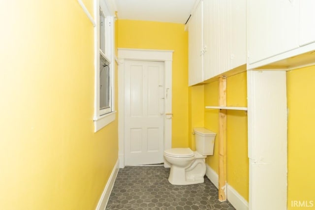 bathroom featuring baseboards and toilet