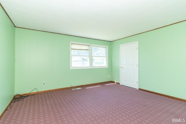 carpeted empty room featuring baseboards