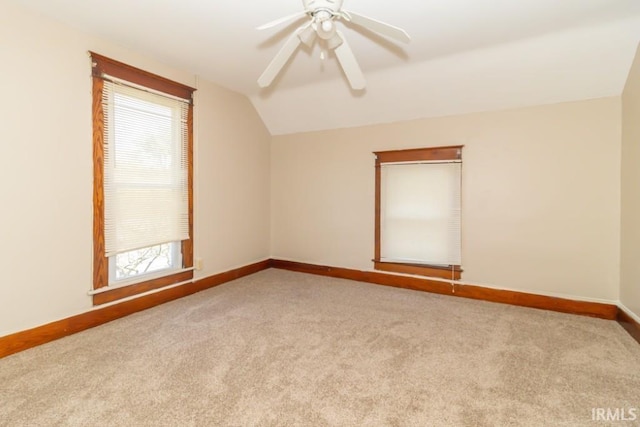 empty room with vaulted ceiling, plenty of natural light, carpet, and baseboards