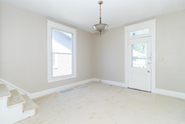 entrance foyer with light carpet and baseboards