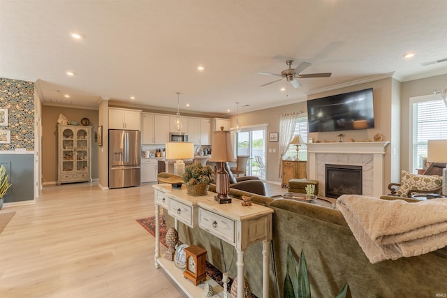 5512 Abbe Wood Dr, Newburgh, IN 47630 - living area featuring a tile fireplace, crown molding, baseboards, a ceiling fan, and healthy amount of natural light