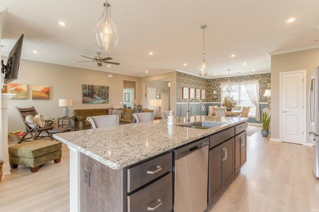 5512 Abbe Wood Dr, Newburgh, IN 47630 - kitchen with stainless steel appliances, a sink, light wood-style flooring, crown molding, and an island with sink