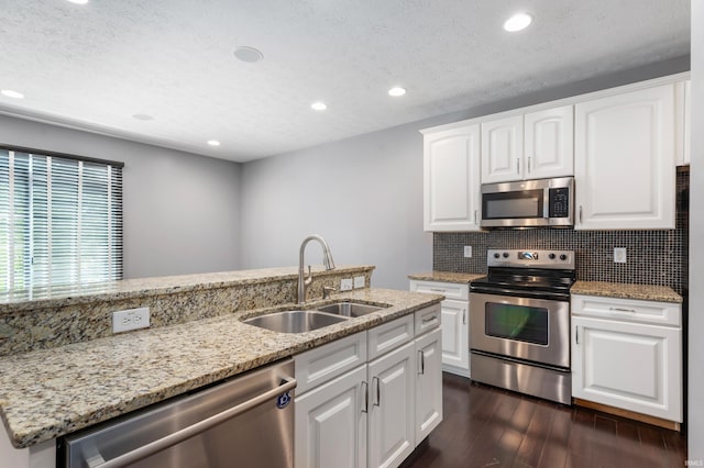 2378 The Springs Dr, Indianapolis, IN 46260 - kitchen with appliances with stainless steel finishes, a sink, dark wood-style flooring, light stone counters, and tasteful backsplash