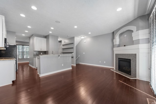 2378 The Springs Dr, Indianapolis, IN 46260 - unfurnished living room with a fireplace, dark wood finished floors, baseboards, and recessed lighting