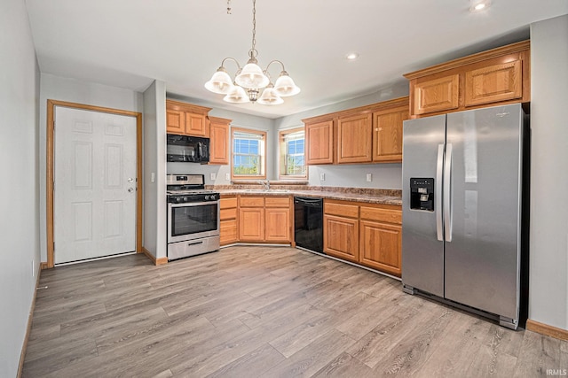 26183 Northland Crossing Dr, Elkhart, IN 46514 - kitchen with black appliances, a sink, a chandelier, light wood-style floors, and pendant lighting