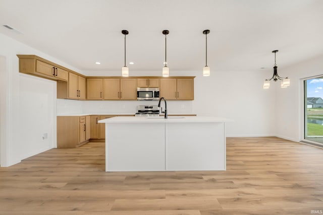 kitchen with appliances with stainless steel finishes, a sink, light countertops, light wood-type flooring, and recessed lighting