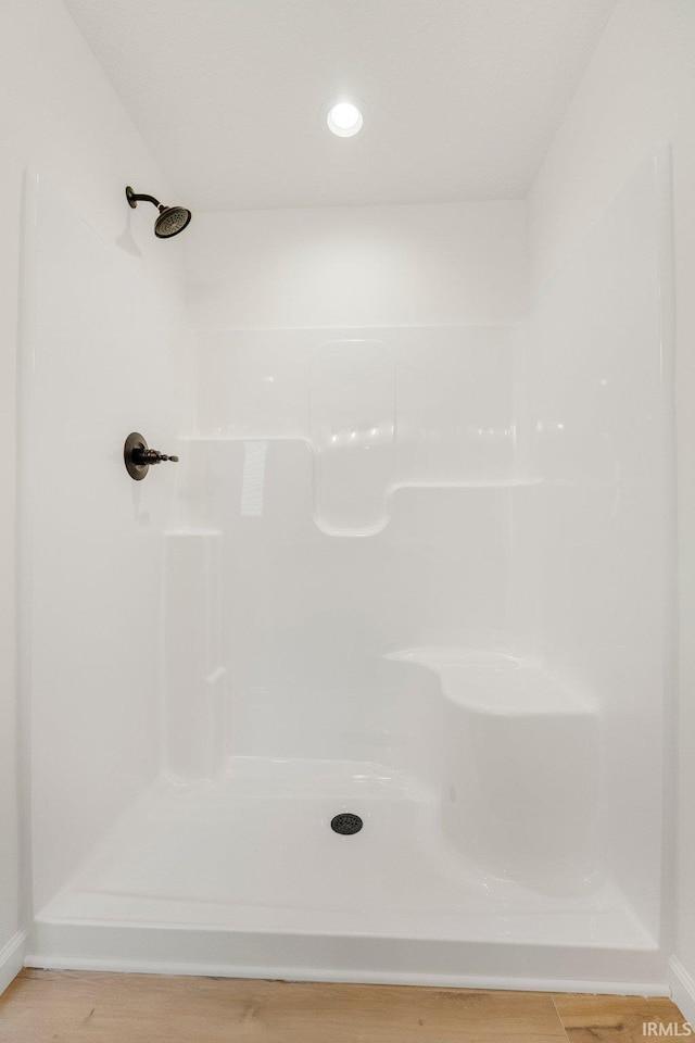full bath featuring wood finished floors and a shower