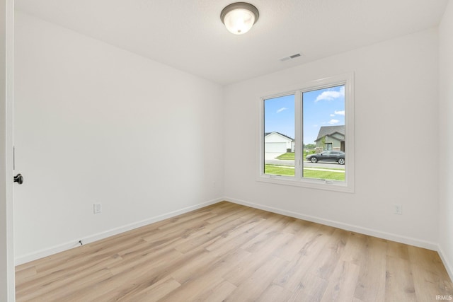 empty room featuring light wood finished floors and baseboards