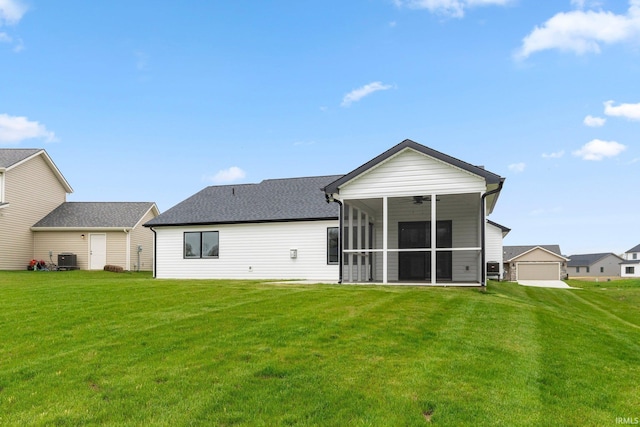 rear view of house with a sunroom, a lawn, and a ceiling fan