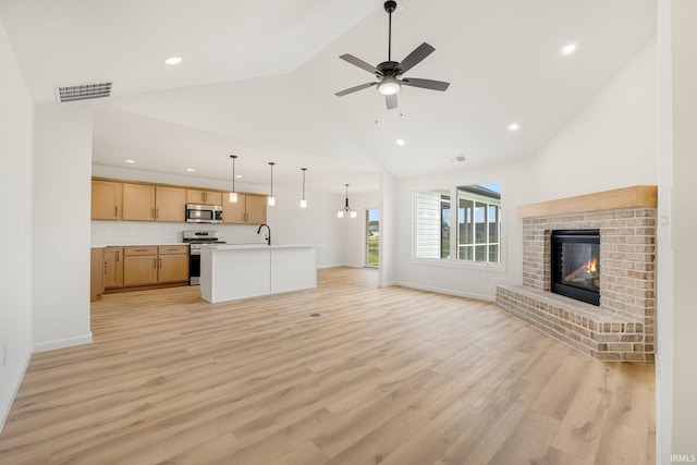 unfurnished living room featuring recessed lighting, high vaulted ceiling, light wood-style flooring, a brick fireplace, and ceiling fan
