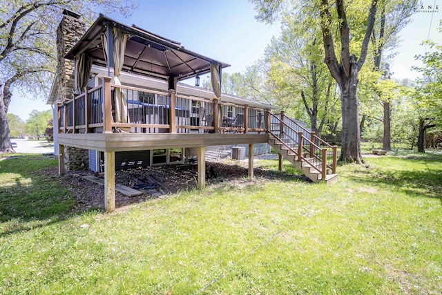 back of property with a gazebo, a chimney, a yard, and a deck