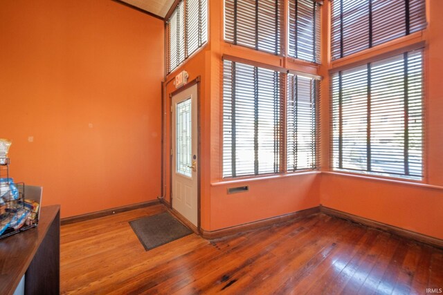 28 N Washington St, Knightstown, IN 47362 - foyer entrance with wood-type flooring, a towering ceiling, and baseboards