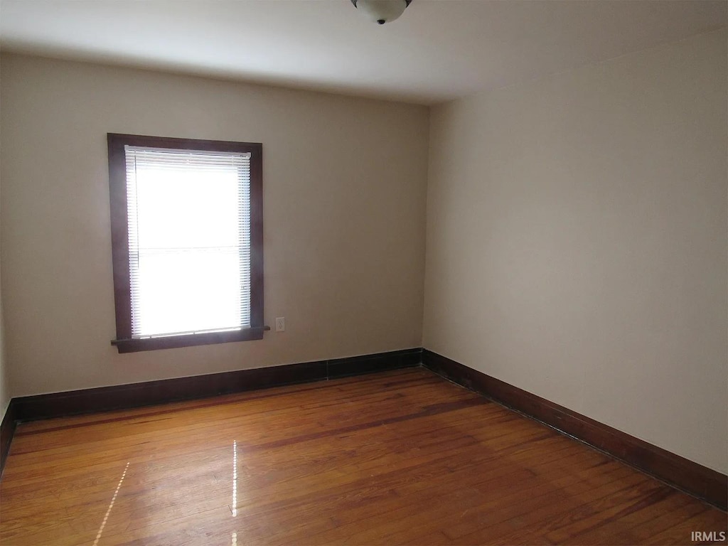 unfurnished room with wood finished floors and baseboards