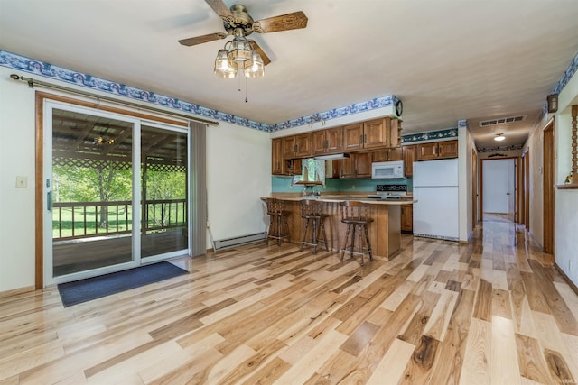 2105 N 100 W, Winchester, IN 47394 - kitchen featuring white appliances, a peninsula, baseboard heating, light wood-style floors, and ceiling fan