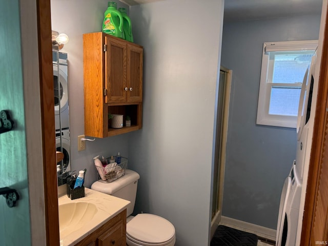 310 Edgeway Dr, Alexandria, IN 46001 - bathroom featuring stacked washer / dryer, vanity, toilet, a shower stall, and baseboards