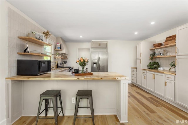 736 Paradise Ave, Lafayette, IN 47905 - kitchen featuring open shelves, appliances with stainless steel finishes, butcher block countertops, light wood-style flooring, and a peninsula