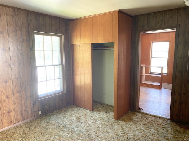 710 N Union St, Union City, IN 47390 - unfurnished bedroom with a closet, wood walls, multiple windows, and carpet floors