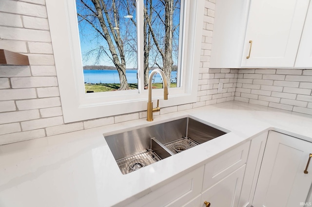 6540 S 070 E, Wolcottville, IN 46795 - kitchen view of a sink, tasteful backsplash, white cabinetry, and light countertops