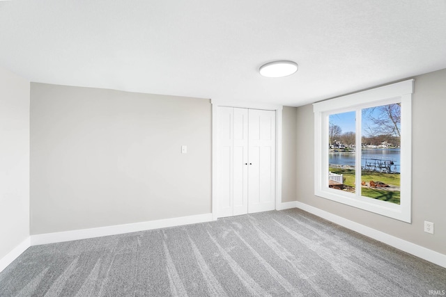 6540 S 070 E, Wolcottville, IN 46795 - unfurnished bedroom featuring a water view, a closet, carpet, and baseboards