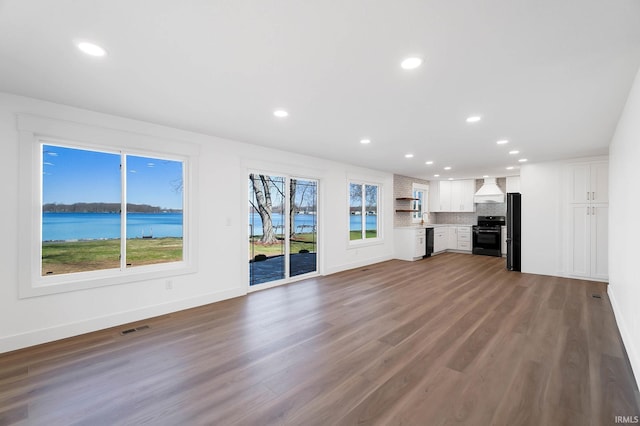 6540 S 070 E, Wolcottville, IN 46795 - unfurnished living room with recessed lighting, wood finished floors, baseboards, a water view, and a sink