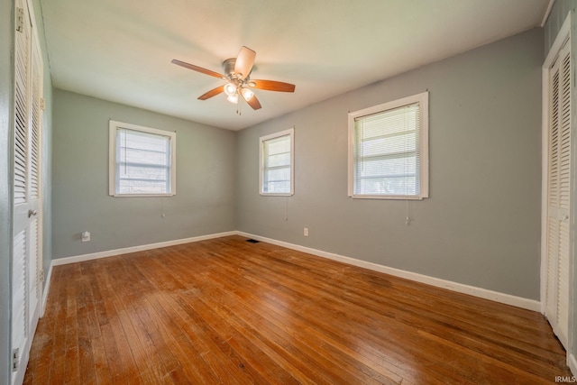 323 N Berkley Rd, Kokomo, IN 46901 - unfurnished bedroom with hardwood / wood-style flooring, a closet, baseboards, and a ceiling fan