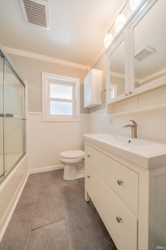 323 N Berkley Rd, Kokomo, IN 46901 - bathroom with wainscoting, toilet, ornamental molding, vanity, and enclosed tub / shower combo