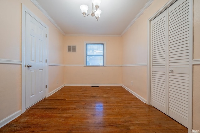 323 N Berkley Rd, Kokomo, IN 46901 - unfurnished bedroom featuring a chandelier, wood finished floors, crown molding, and baseboards