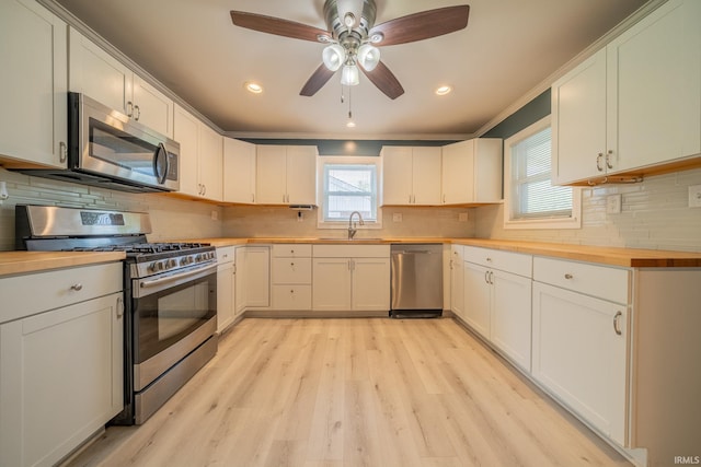 323 N Berkley Rd, Kokomo, IN 46901 - kitchen featuring stainless steel appliances, butcher block counters, light wood finished floors, a sink, and a ceiling fan