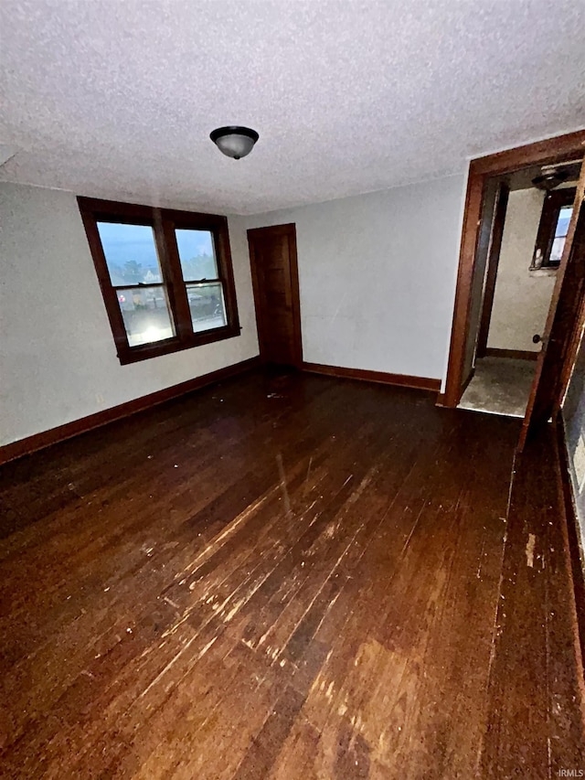 312 Horace Mann Ct, Marion, IN 46952 - spare room featuring a textured ceiling, dark wood-style flooring, and baseboards
