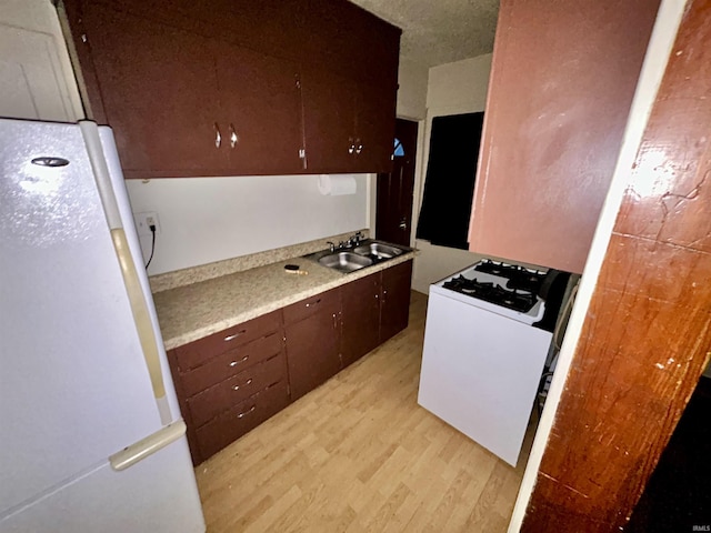 312 Horace Mann Ct, Marion, IN 46952 - kitchen featuring freestanding refrigerator, range with gas cooktop, light wood-style floors, light countertops, and a sink