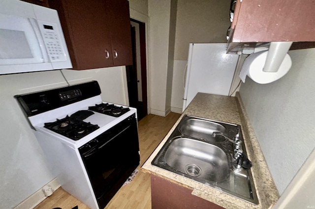 312 Horace Mann Ct, Marion, IN 46952 - kitchen featuring white appliances, light wood-type flooring, a sink, and baseboards