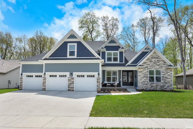 craftsman-style home featuring a front yard, stone siding, concrete driveway, and an attached garage