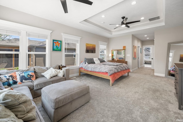 bedroom featuring recessed lighting, light colored carpet, a tray ceiling, baseboards, and ceiling fan