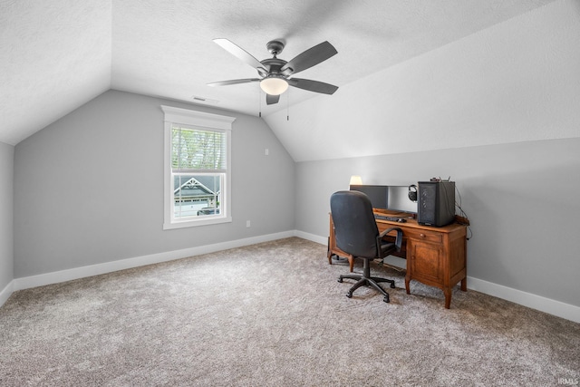 office area with vaulted ceiling, a ceiling fan, carpet, baseboards, and a textured ceiling