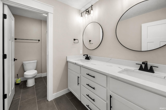 bathroom with double vanity, toilet, tile patterned flooring, and baseboards