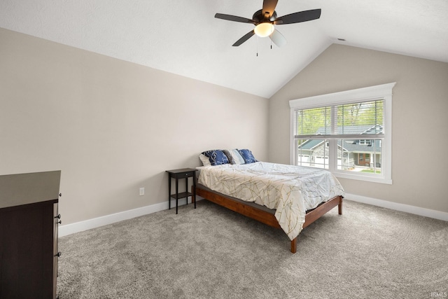 carpeted bedroom featuring lofted ceiling, baseboards, and ceiling fan