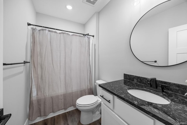 bathroom featuring wood finished floors, vanity, toilet, shower / bath combo, and recessed lighting
