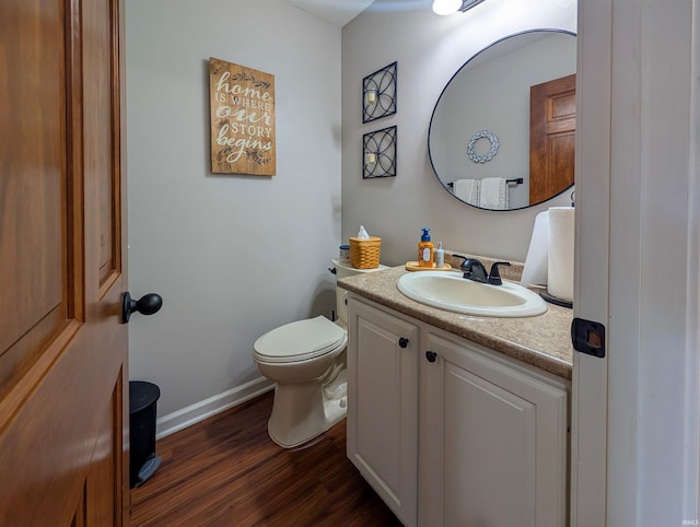 bathroom featuring wood finished floors, vanity, toilet, and baseboards