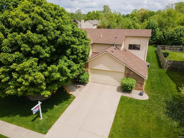view of front of house featuring an attached garage, concrete driveway, and a shingled roof
