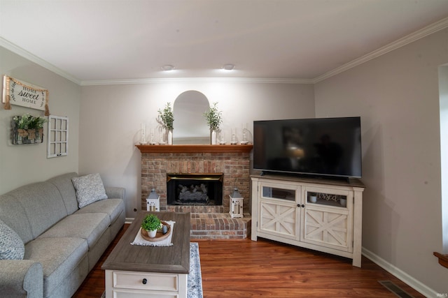 living room featuring crown molding, wood finished floors, a fireplace, and baseboards