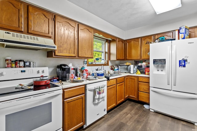 2704 President Ln, Kokomo, IN 46902 - kitchen with white appliances, under cabinet range hood, dark wood finished floors, light countertops, and brown cabinets