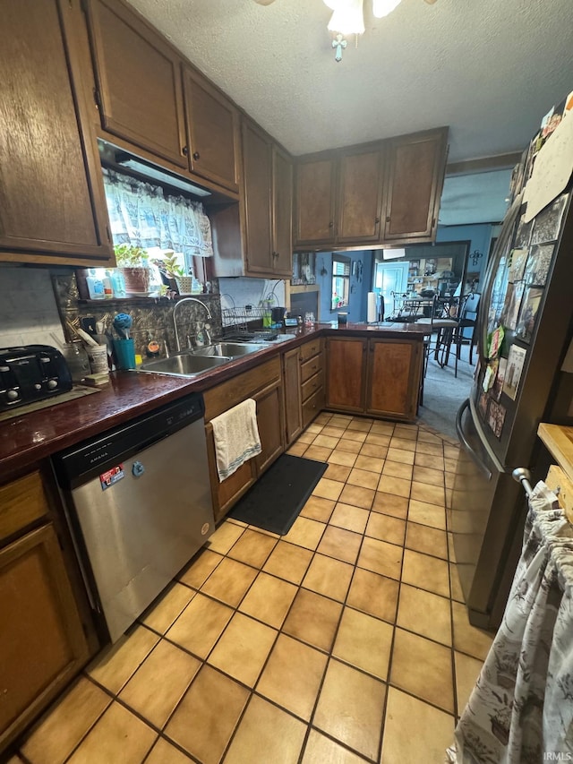 515 E Washington St, Attica, IN 47918 - kitchen with appliances with stainless steel finishes, dark countertops, light tile patterned flooring, a textured ceiling, and a sink