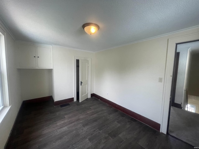 1307 High St, Logansport, IN 46947 - unfurnished room with dark wood-type flooring, baseboards, crown molding, and a textured ceiling