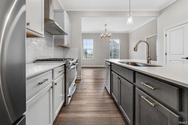 105 Parkerwood Ln, West Lafayette, IN 47906 - kitchen with stainless steel appliances, wall chimney range hood, a sink, dark wood-style flooring, and light countertops