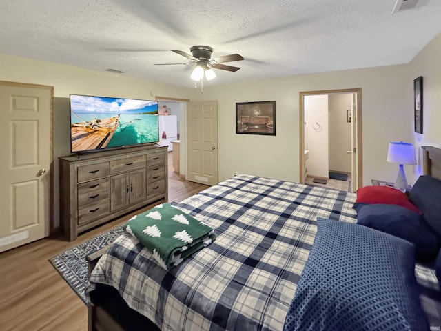 2548 N Letterman Rd, Paragon, IN 46166 - bedroom featuring a textured ceiling, wood finished floors, ceiling fan, and ensuite bath