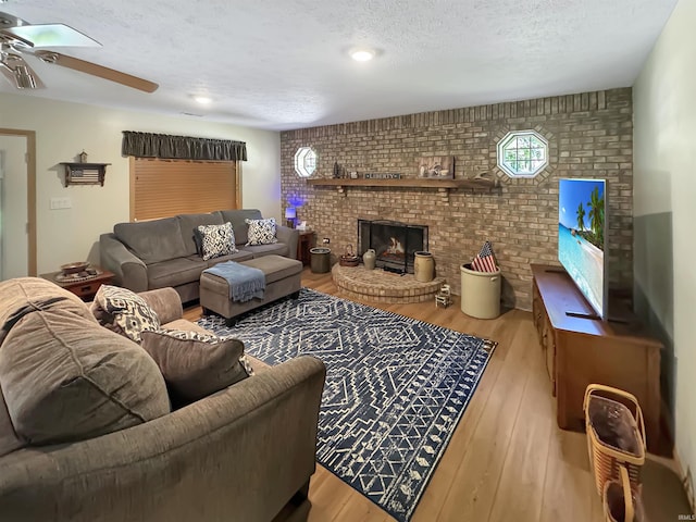 2548 N Letterman Rd, Paragon, IN 46166 - living area with brick wall, a ceiling fan, a textured ceiling, wood finished floors, and a brick fireplace