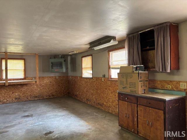 507 E Viola Ave, Washington, IN 47501 - kitchen featuring unfinished concrete floors, a wainscoted wall, and brown cabinetry