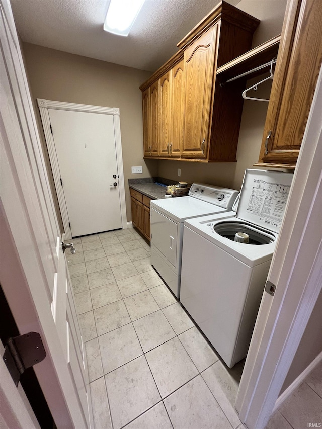 1155 N Fox Ridge Links Dr, Vincennes, IN 47591 - washroom featuring cabinet space, washer and dryer, a textured ceiling, and light tile patterned floors